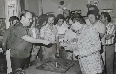 Mirando piezas de ajedrez en el VIII Campeonato de Ajedrez de Educación y Descanso 1956 (1)