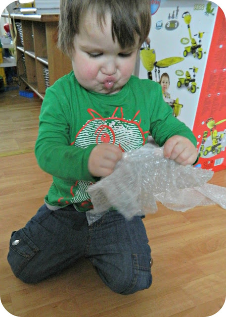 Small boy toddler popping bubble wrap