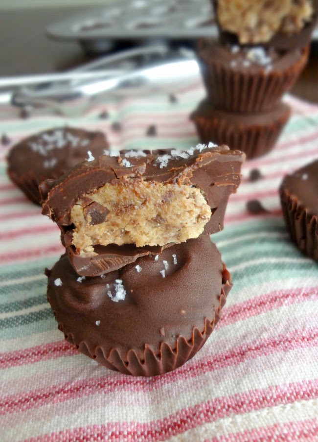 brown butter peanut butter cookie dough cups stacked on pink dishtowel