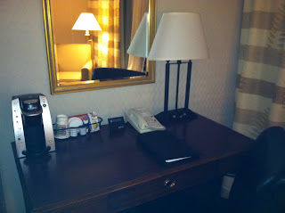 a desk with a lamp and phone on it