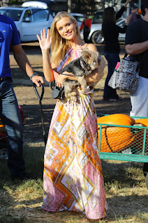 Joanna Krupa holding her dog and waving to cameras