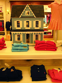 Dolls' house displayed in a children's wear department.