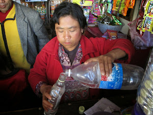 A lady selling "ARA" the home-made local brew of Bhutan.