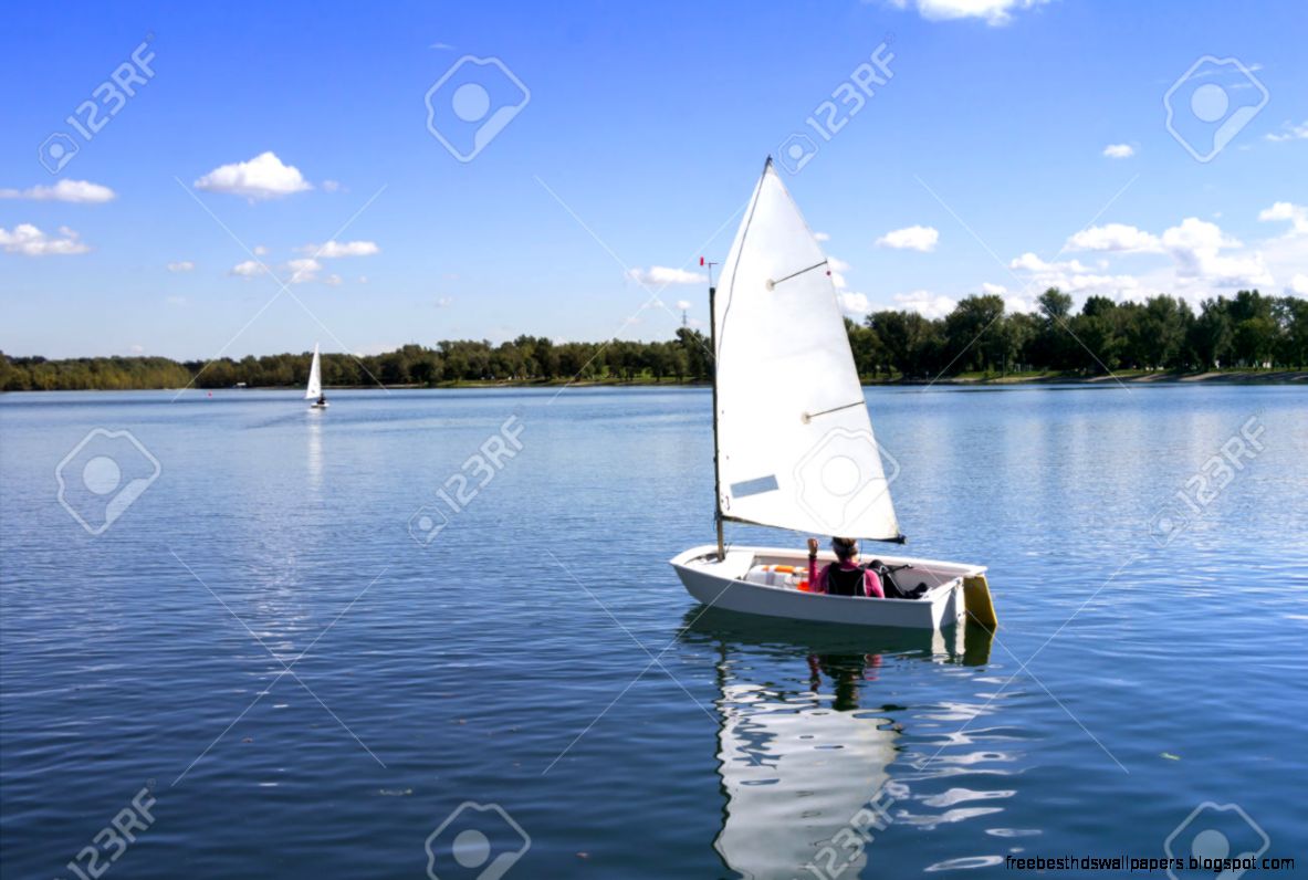 Small White Boat Sailing On The Lake On A Beautiful Sunny Day Small White Boat Sailing On The Lake On A Beautiful Sunny Day