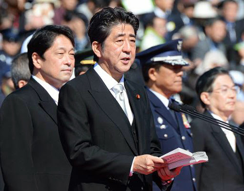 Thủ tướng Nhật Shinzo Abe (giữa) phát biểu trước 4.000 binh sĩ của Lực lượng Phòng vệ Nhật Bản tại Trại huấn luyện Asaka hôm nay. Đứng sau ông Abe là Bộ trưởng Quốc phòng Nhật Itsunori Onodera. Ảnh: AFP