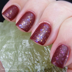Matted nail art look of flakies over oxblood polish.