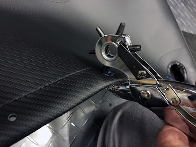 Using punch tool to cut holes into the boot cover