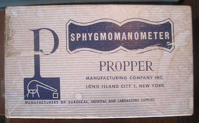 Worn paperboard box with word SPHYGMOMANOMETER on it