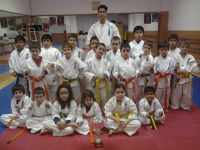 competidor de karate con grupo de pequeños karatekas