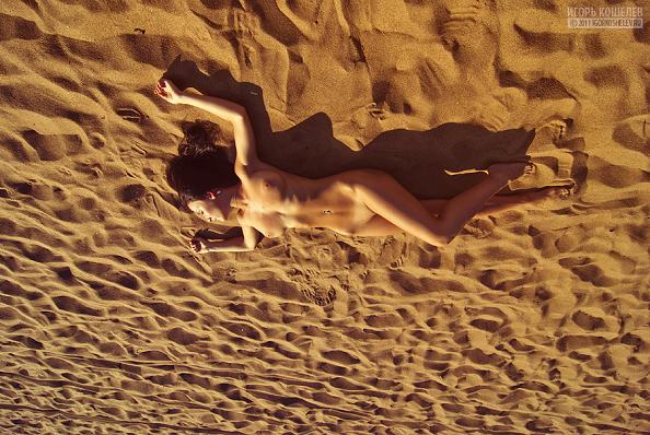 mulher nua pelada deitada na areia