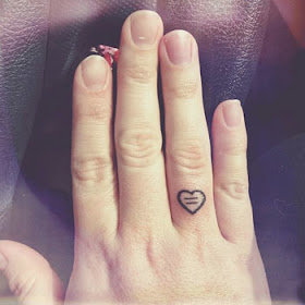Tatuagem de coração pequena no dedo feminino