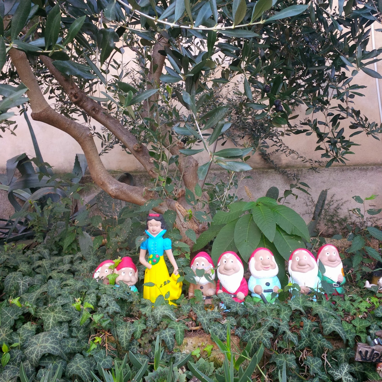 Disney figurines under an olive tree in the garden of a cafe in Arqua Petrarca