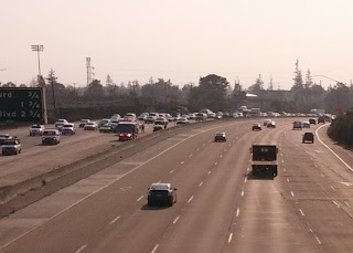 Ambulances and police officers respond to rush hour freeway traffic collision.