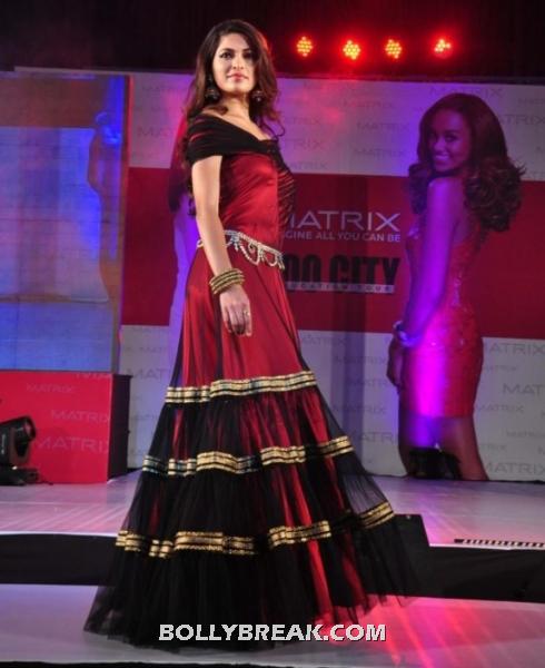 Parvathy omanakuttan poses in a very elegant red and maroon off shoulder gown.  - parvathy omanakuttan in red floor length gown walking the ramp