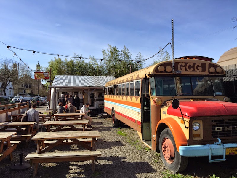 Outdoor and indoor seating in an old school bus at The Grilled Cheese Grill