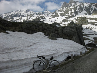 Bicycle parked next to a snowbank near the summit of the Gotthardpass, Switzerland