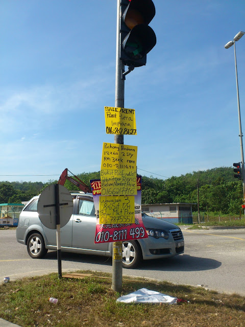 交通灯前的大耳窿招贴和地产广告，已成马来西亚特色