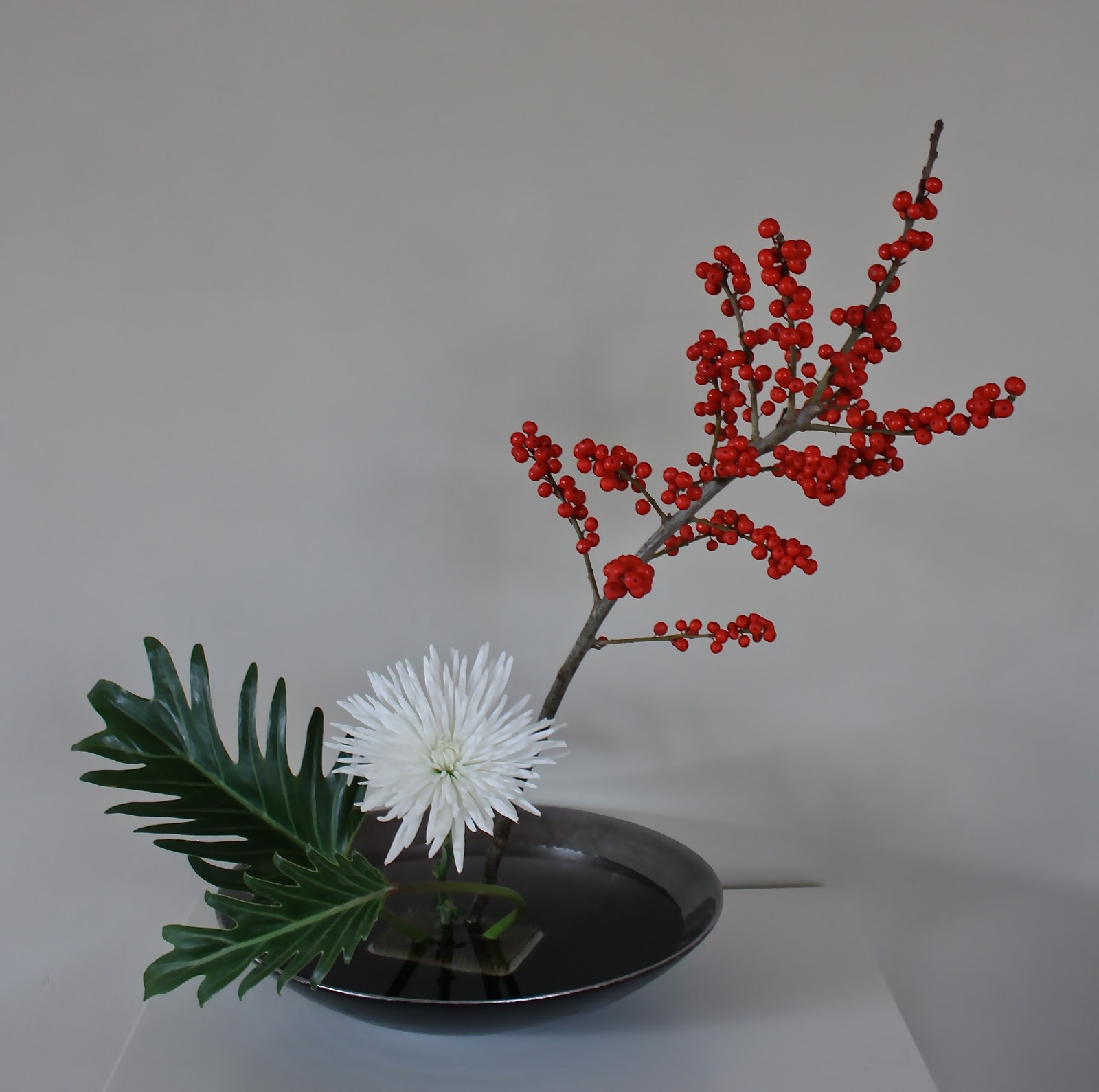 WABISABI Ikebana con illex opaca, crisantemo y philodendro. Christmas