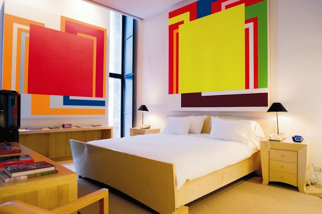 Photo of one of the bedrooms with wooden bed and large colorful photos on the walls 