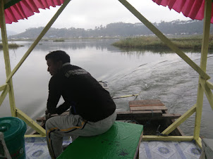 Boatman  Shri  Pukhrambam.Gandhi.Meitei  at the rudder of the boat controlling the route.