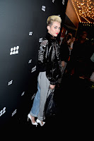 Miley Cyrus  on the black carpet posing for cameras