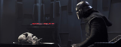 Adam Driver as Kylo Ren staring at Darth Vader's helmet in Star Wars The Force Awakens