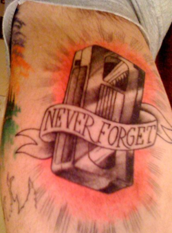 tatuaje de una cinta vhs que dice: never forget