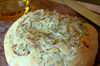 loaf of Focaccia with Onion and Rosemary on a cutting board