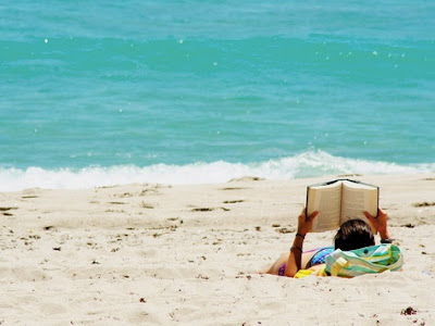 disfrutando de un libro en la playa