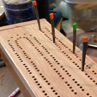 close up of cribbage board top and four pegs