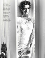 Penelope Cruz standing at the door in a white dress