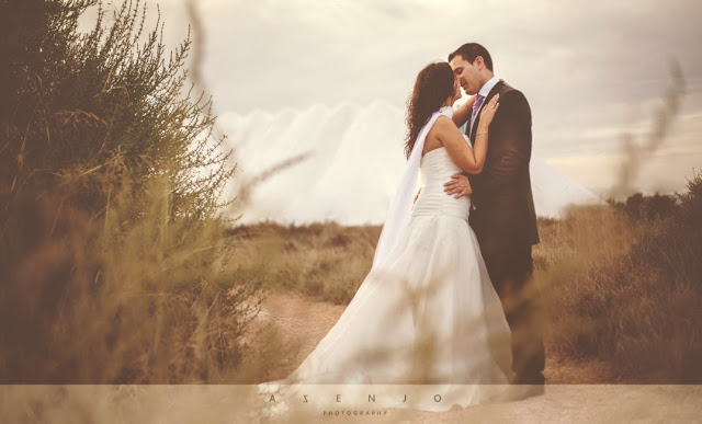 novios besandose junto montañas de sal