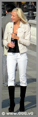 Slim blonde girl in white jeans on the street 