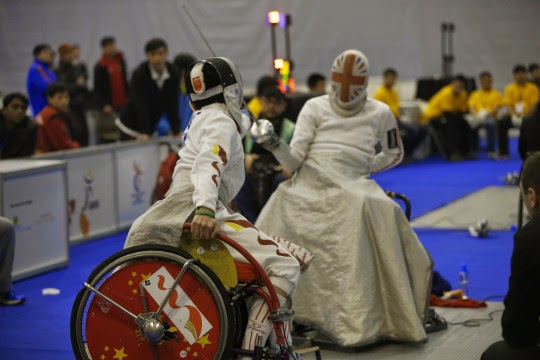 Photo of two wheelchair users fencing