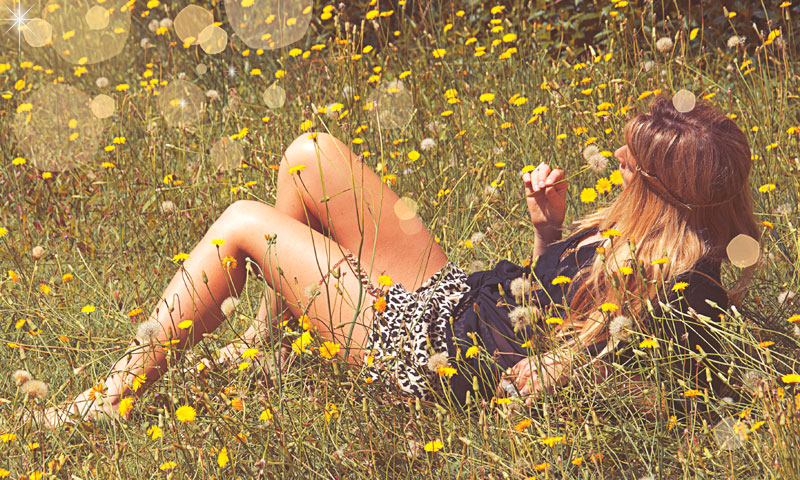 Молоденькая нимфа греется под солнцем сидя голышом на поляне