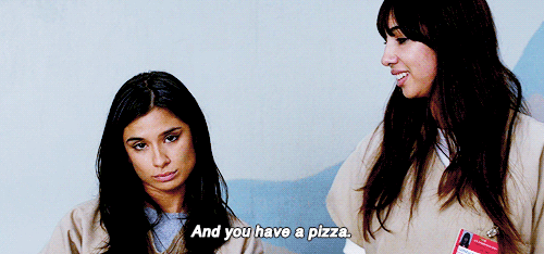 No gif: Outras duas meninas, dessa vez latinas, olhando para a câmera e uma delas diz: E então você tem uma pizza.