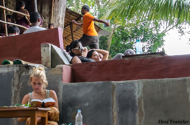 girl reading book on india under the mango tree restaurant