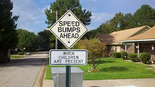 funny road sign children are speed bumps