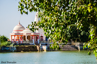 a hindu temple near a pond in a village in India