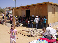 People waiting in the shade of the building for groceries