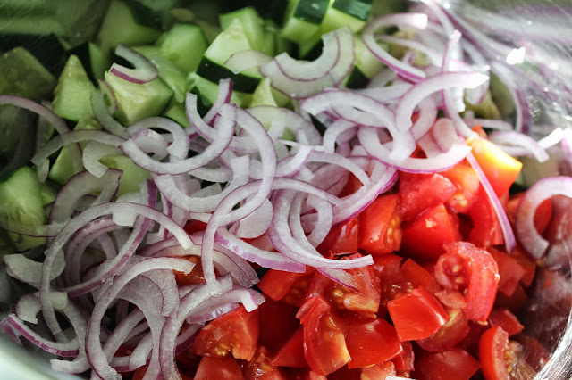 Diced cucumbers and tomatoes with thinly sliced red onion