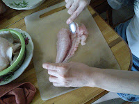 Scraping the meat off the fish skin