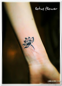 a black and white lotus flower tattoo on the arm