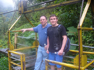 a couple of men standing on a yellow metal bridge