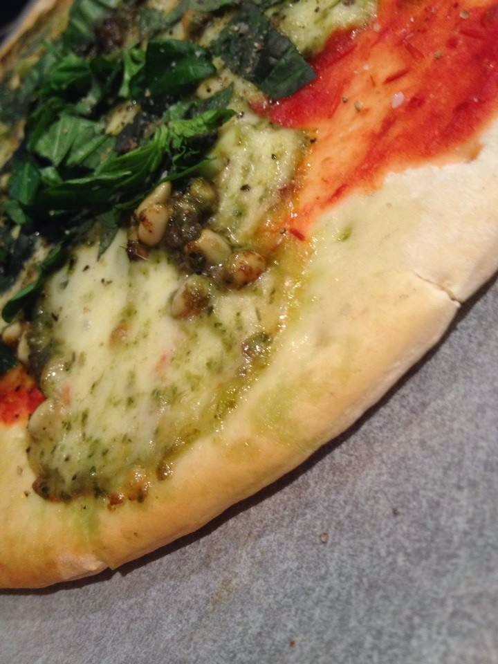 Pesto, anchovy & bocconcini pizza a man in his kitchen