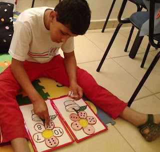 Eduardo sentado no tapete concluindo a segunda etapa do jogo com números de 6 até 10