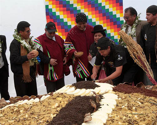 El presidente Evo Morales y el director de la FAO, el brasileño José Graziano da Silva, degustan del gigantesco plato de "pisara". | Foto: Efe