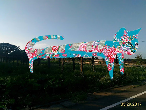 「2017桃園地景藝術節」裝置藝術《花貓愛魚》,設置於桃園觀音主展區的廣福社區活動中心旁之生態池,30米長的花貓正趴在棚架上,凝望著生態池裡的花步魚, 「2017桃園地景藝術節」裝置藝術《花貓愛魚》,設置於桃園觀音主展區的廣福社區活動中心旁之生態池,30米長的花貓正趴在棚架上,凝望著生態池裡的花步魚,