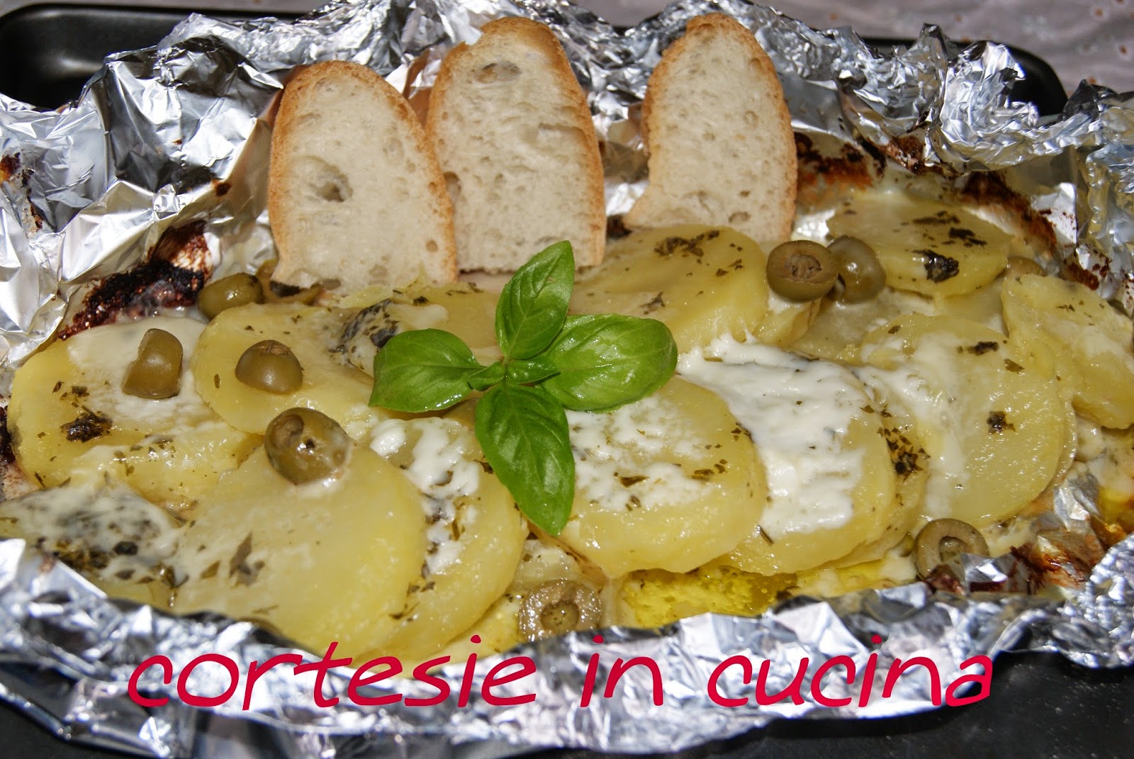 Patate al cartoccio con crescenza olive verdi e pesto al basilico