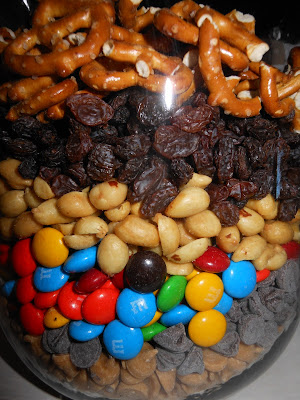 blog+054 Monster Trail Mix This Monster Trail Mix Recipe is so addictive you'll be taking it everywhere!  It's a great mixture of sweet, salty, and savory making it the best trail mix recipe I've ever made!
  Monster Trail Mix Recipe
My husband and I love Archer Farm's (aka Target) Monster Trail Mix.  Lately I've noticed that you get alot less for alot more...which is NO fun, especially in this economy! Have you noticed how manufacturers are making the packaging smaller but charging the same or more?
Well once someone pointed it out to me I really began to notice. So I decided why not make my own... and let me tell you... we wound up with a TON more for about the same price... it almost filled up a gallon jar! Anyway, this Monster Trail Mix Recipe is an absolute MUST HAVE when we are trying to Survive a Roadtrip with our toddler....it's the perfect little treat for him to snack on in the backseat.  I get these fun little monster snack containers-- which Little Man just LOVES! The Ingredients
16oz Salted Peanuts
1 Cup Raisins
1 Cup M&M's Candy
1 Cup Peanut Butter Chips
1 Cup Chocolate Chips
2 Cups Pretzels (I added because I wanted more salty- there seemed to be enough sugar) *really you can add whatever you like to the mix... I was thinking of adding Chex cereal, cashews, walnuts, etc. Directions:
Pour everything into a container and shake! That's it!  What's your favorite snack mix for on the go? Share in the comments below! Are you like me and always on the hunt for deliciously simple recipes that your family will love?  Here’s a free printable for my 5 FAVORITE one dish meals– they’re perfect for busy nights when you don’t have a ton of time and don’t want to clean a bunch of dishes! Other recipes to try:
Simple Apple Crisp
Coconut Macaroon Cake
Loaded Banana Boats
Copy Cat Cracker Barrel Hashbrown Casserole
Perfectly Glazed Slow Cooker Chicken Recipe